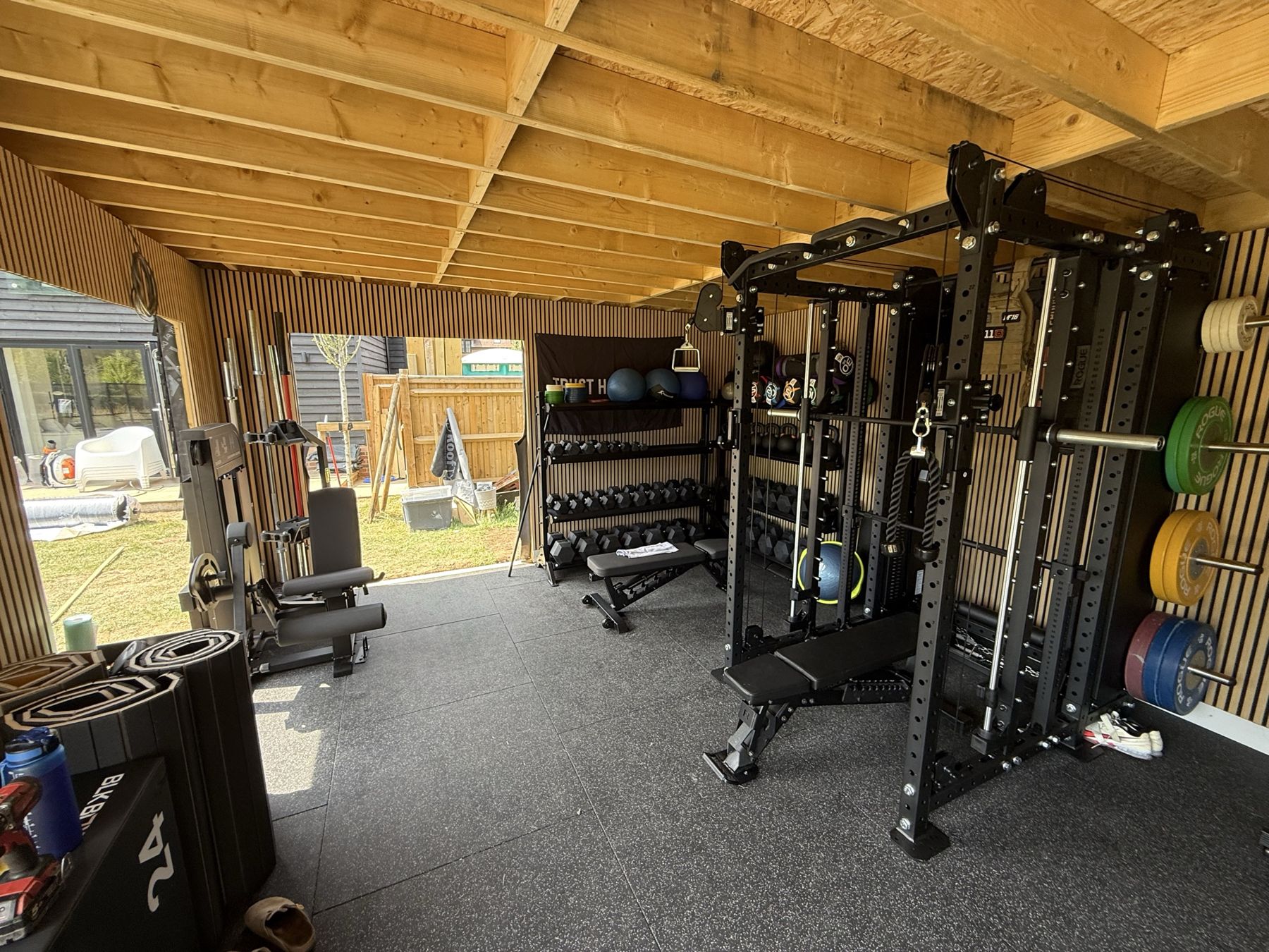 Squat rack in front of glass doors onto the garden